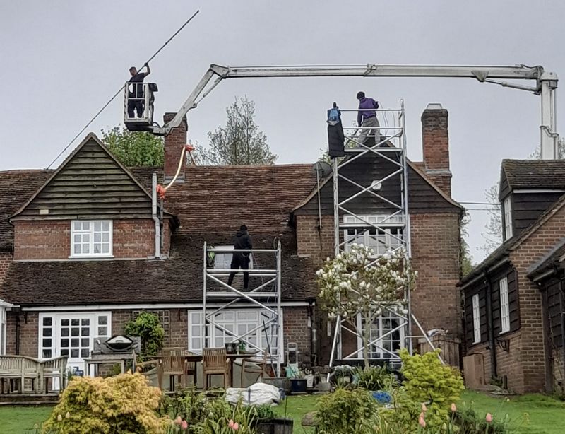 The Moss Cleaners using cherry picker and scaffolding to clean roof safely and professionally in Andover, Hampshire